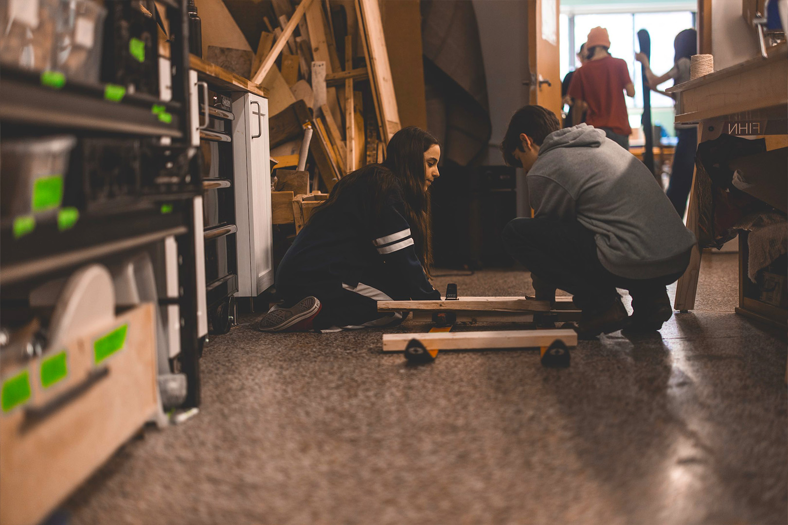 Deux adolescents construisent ensemble une structure dans L'Atelier.